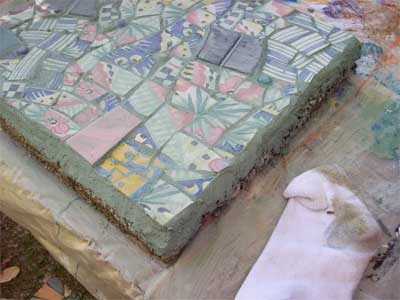 wipe the grout off the surface with an old cotton sock